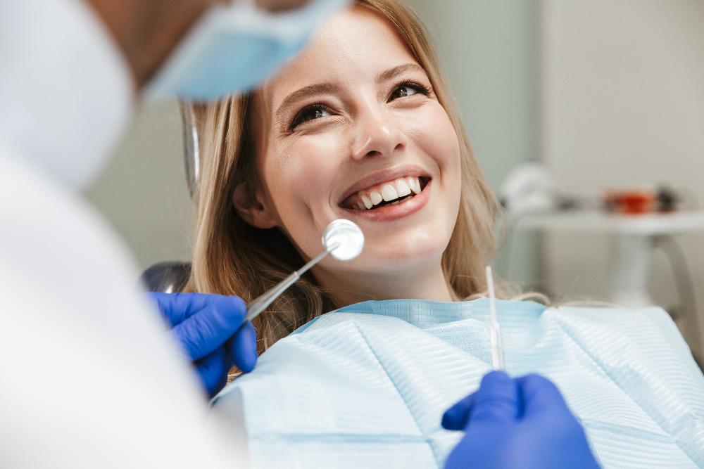 woman sitting in dentist exam chair smiling | farmington hills mi dentist