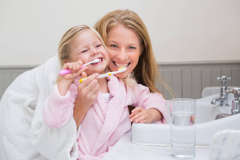 woman and daughter brushing teeth | farmington hills dentist