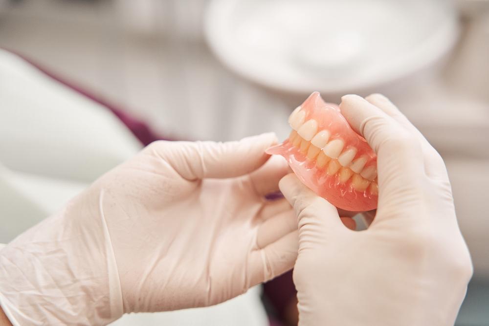 dentist holding dentures in farmington hills