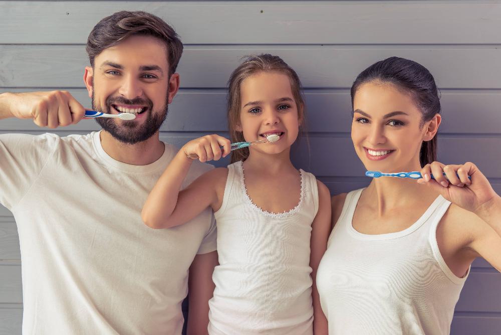 family of three brushing teeth | cosmetic dentist farmington hills mi