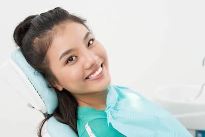 woman sitting in dentist exam chair | dentist farmington hills mi