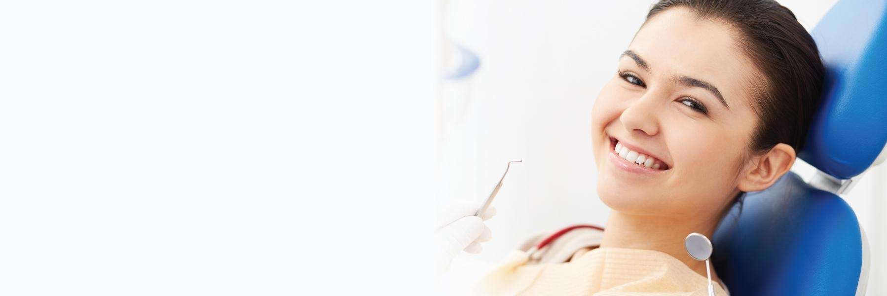 woman smiling in exam chair | dentist farmington hills mi