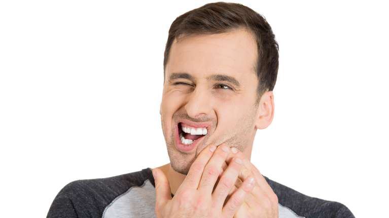 man holding jaw from pain during a dental emergency 
