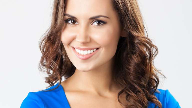 woman in blue shirt smiling | cosmetic dentist farmington hills mi