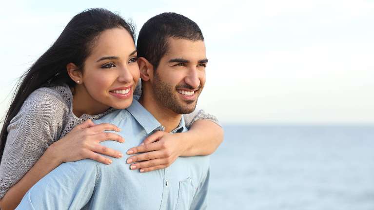 couple at the beach hugging | dentist farmington hills
