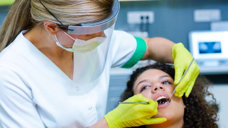 woman receiving dentist exam | dentist farmington hills mi